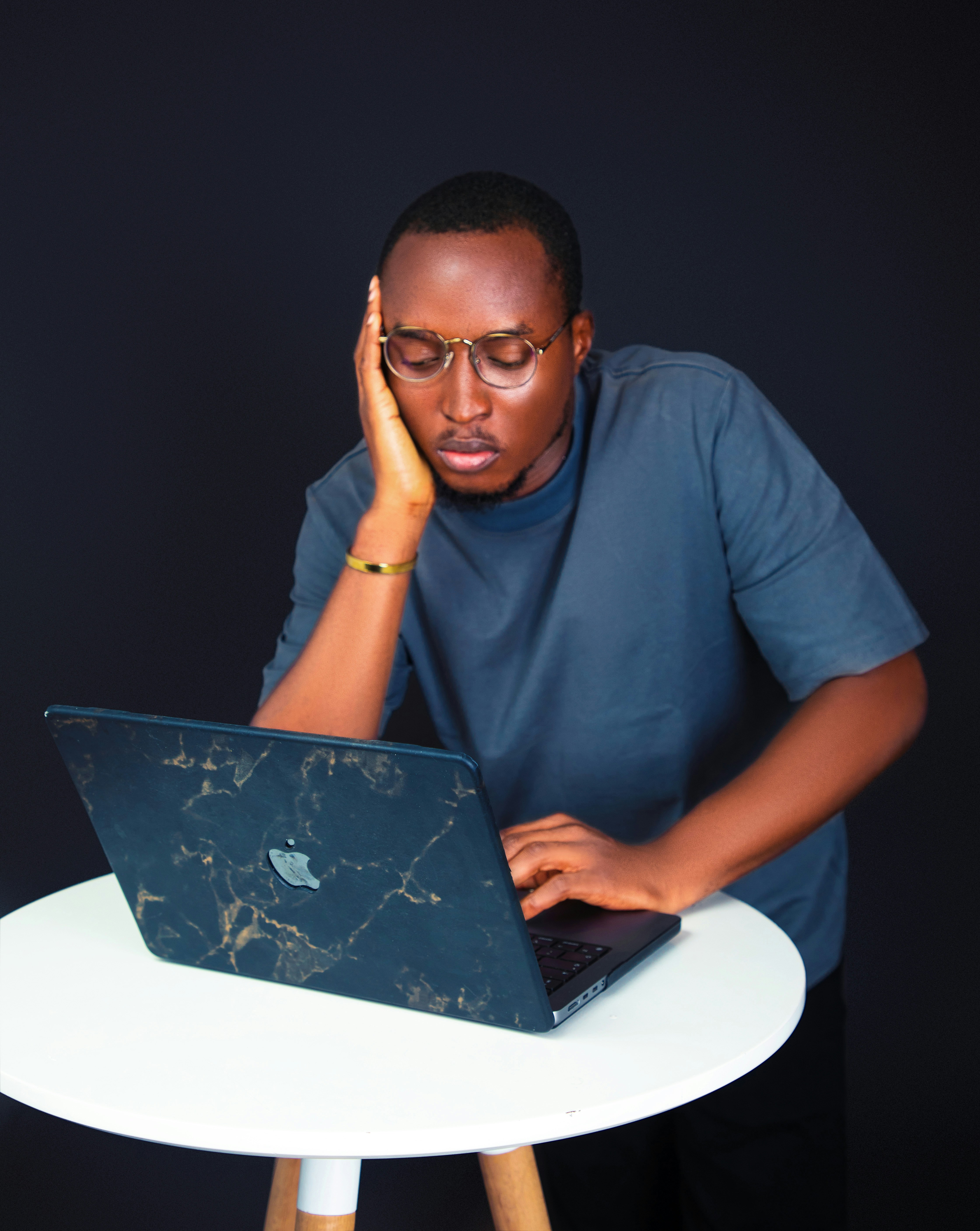 A person looking overwhelmed while using a laptop
